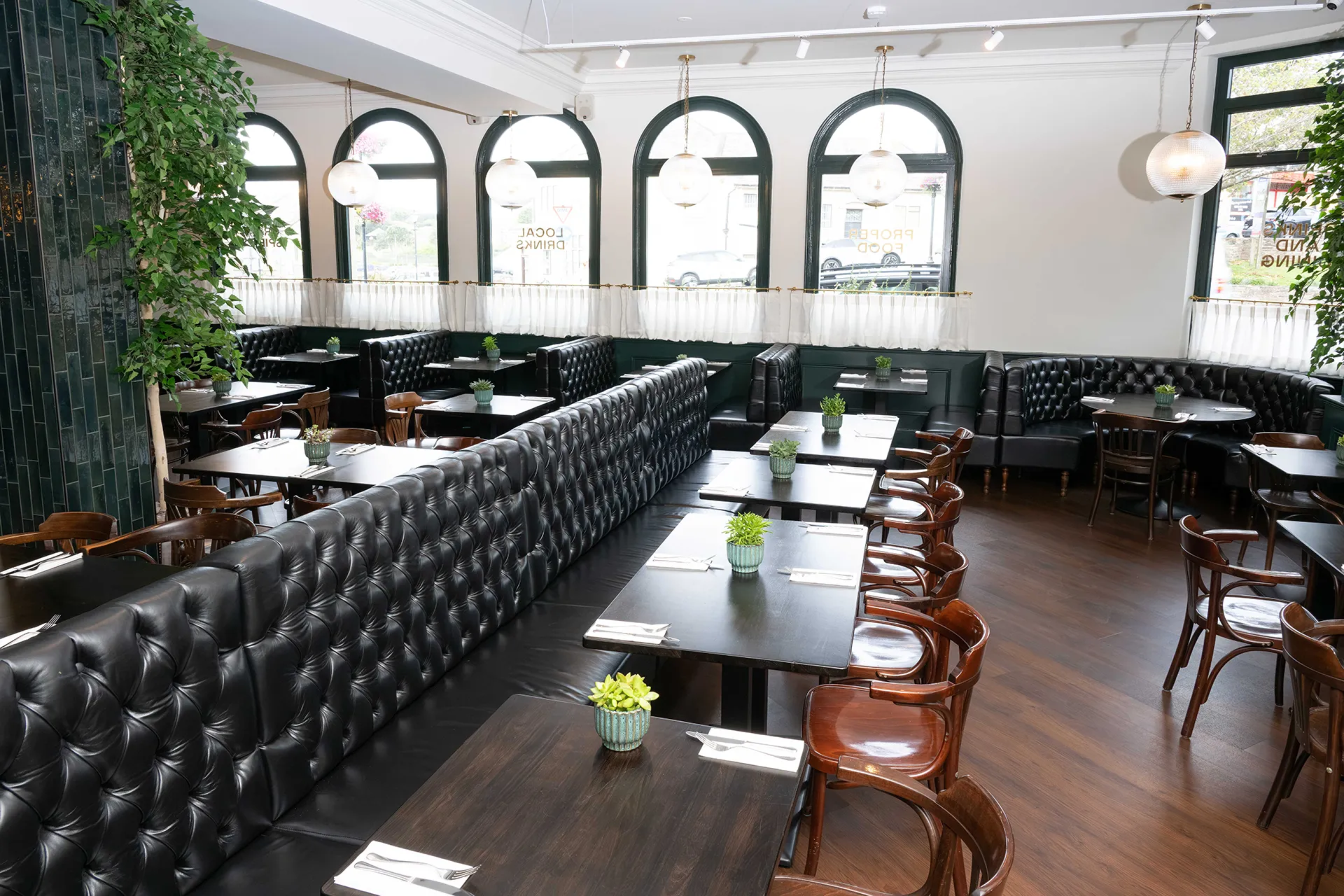 Black leather banquette seating in a bright restaurant interior